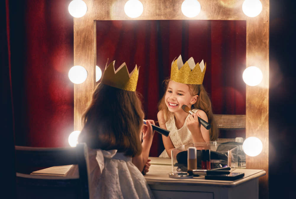 ילדה משחקת בלהיות מלכה מול המראה